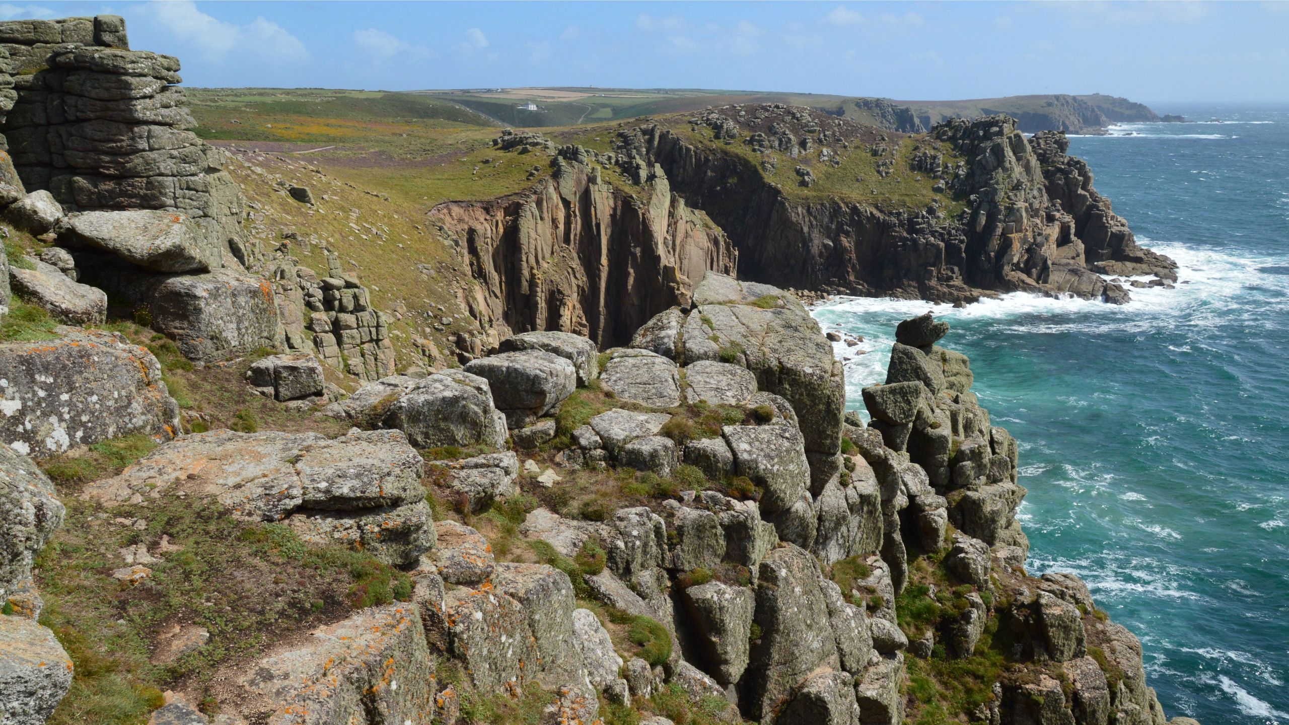 Scenic view of rocky cliffs and vibrant sea at Land's End, Cornwall.